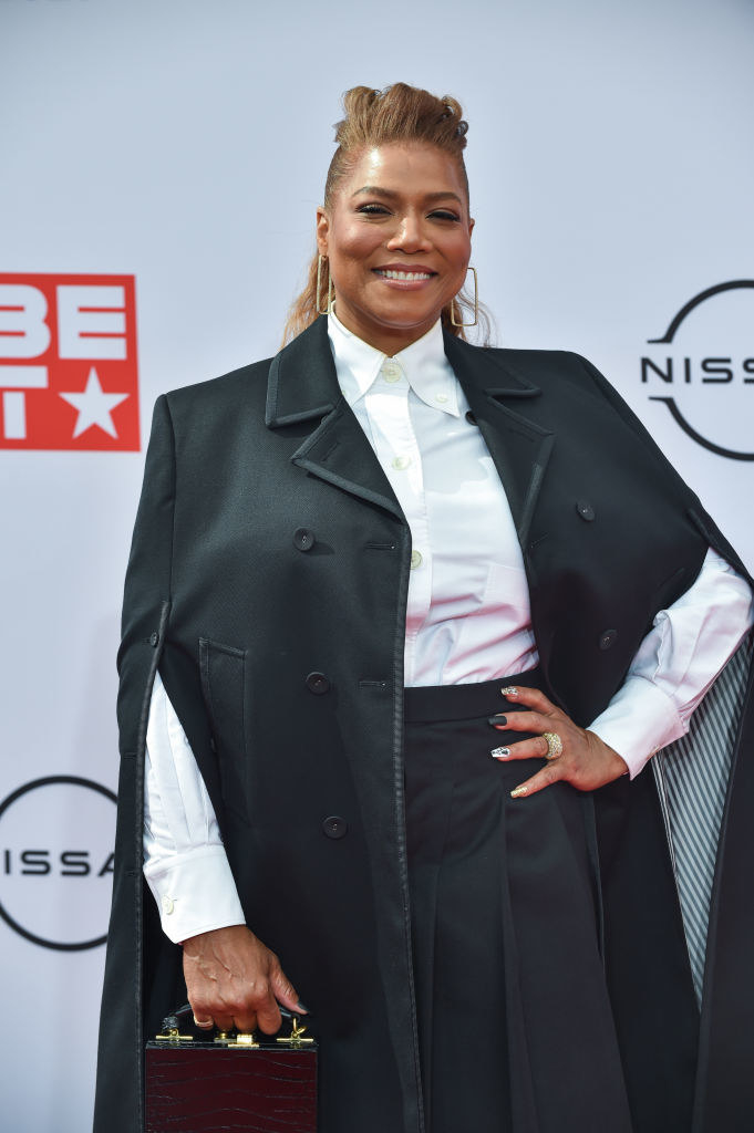 Queen Latifah stands on the red carpet with her hand on her hip
