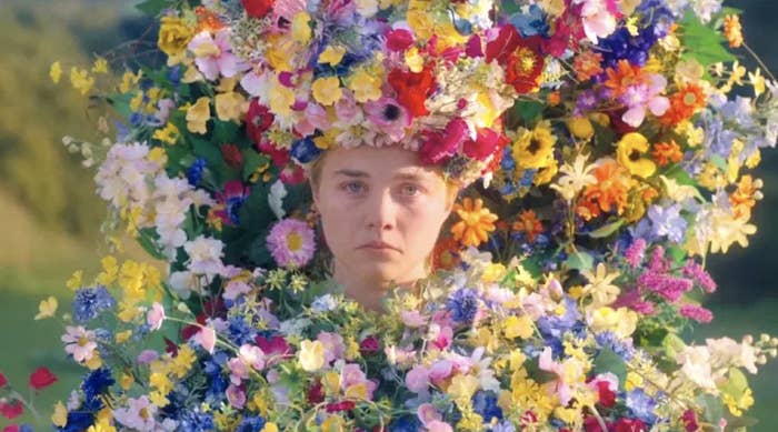 Florence Pugh frowns as she's covered in flowers.