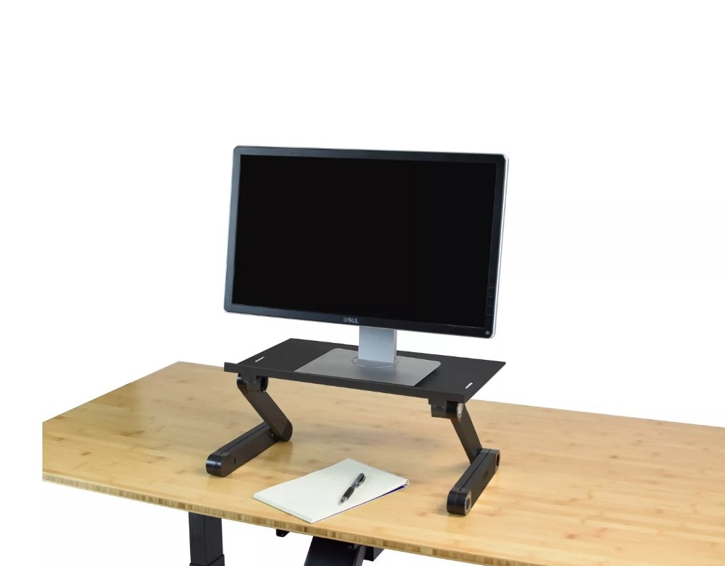 Desktop computer on black desk converter sitting on wooden desk