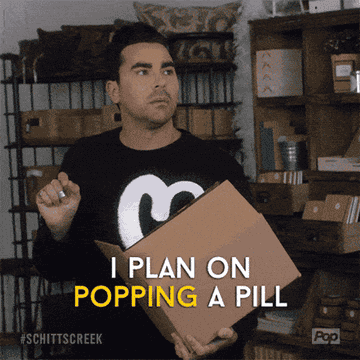 Dan Levy as David in &quot;Schitt&#x27;s Creek&quot; holding a box shares his night routine: pop pills, cry, and fall asleep