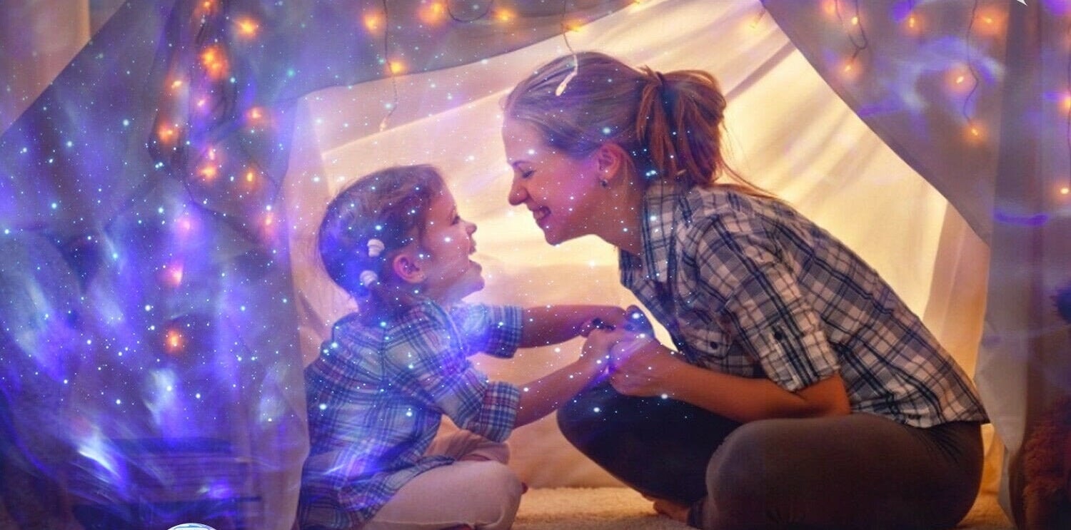 Kid and mom in tent with star projector