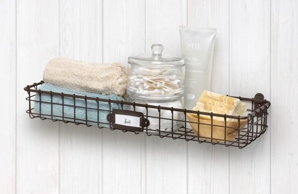 The wall-mounted wire basket holding bathroom items