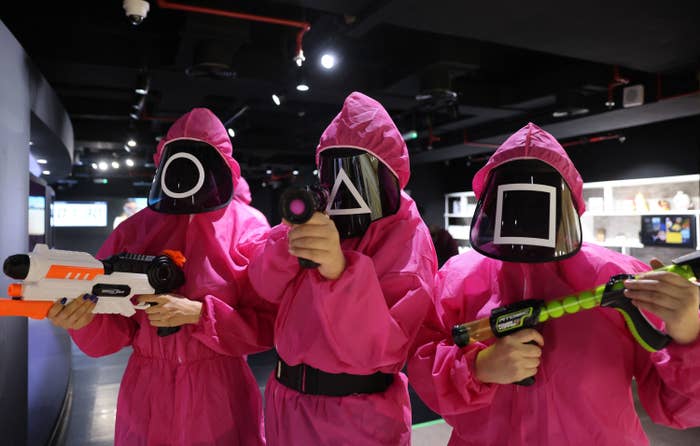 People wearing hazmat-like suit with face masks featuring different shapes