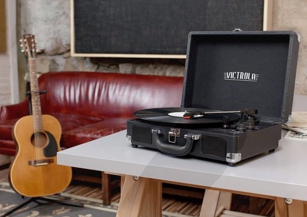 Black suitcase record player playing a record