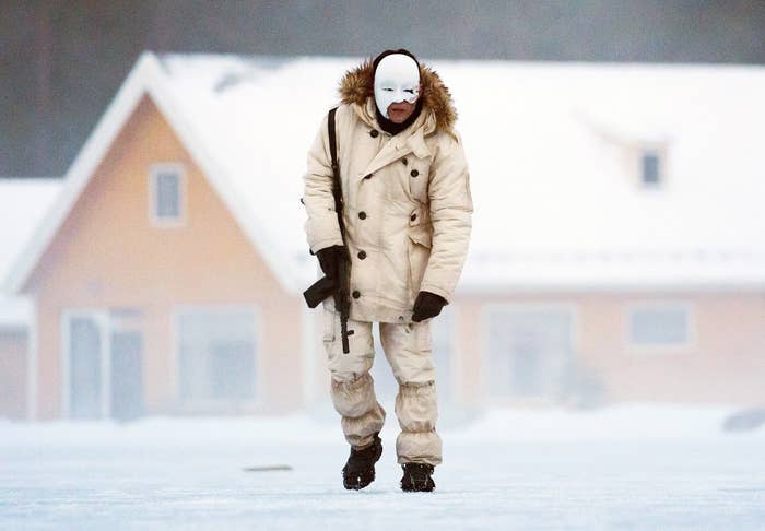 Rami Malek in a mask as he walks a across a frozen lake in No Time To Die