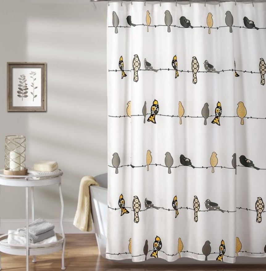 A white shower curtain with yellow and grey birds sitting on wire lines across