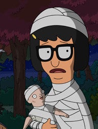 Tina Belcher dressed as a mummy with a mummy-wrapped baby doll.