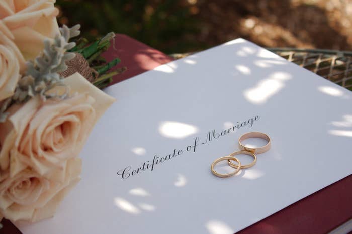 Envelope saying &quot;certificate of marriage&quot; with rings and roses