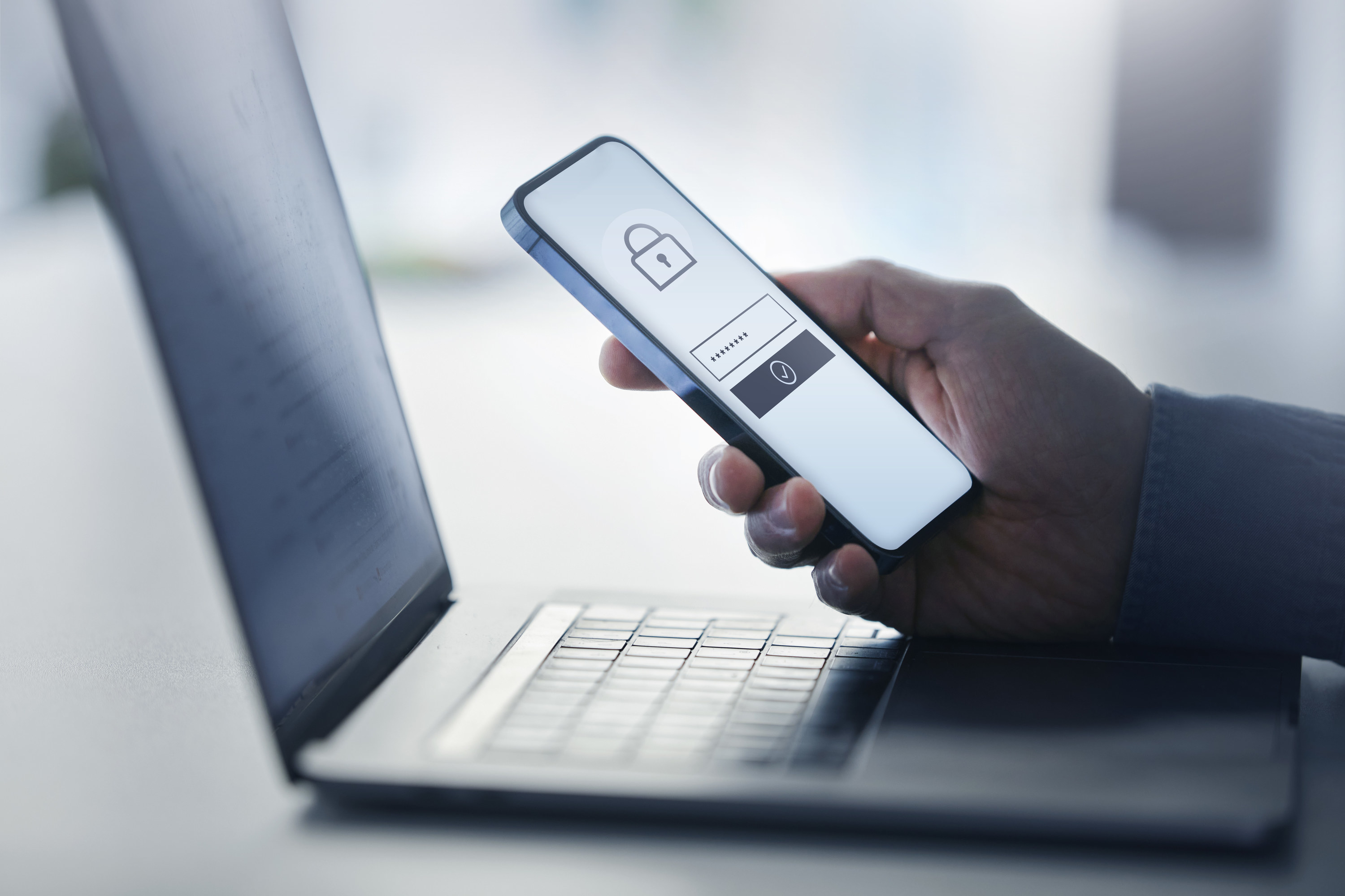 Person holding a smartphone with a lock symbol on the screen