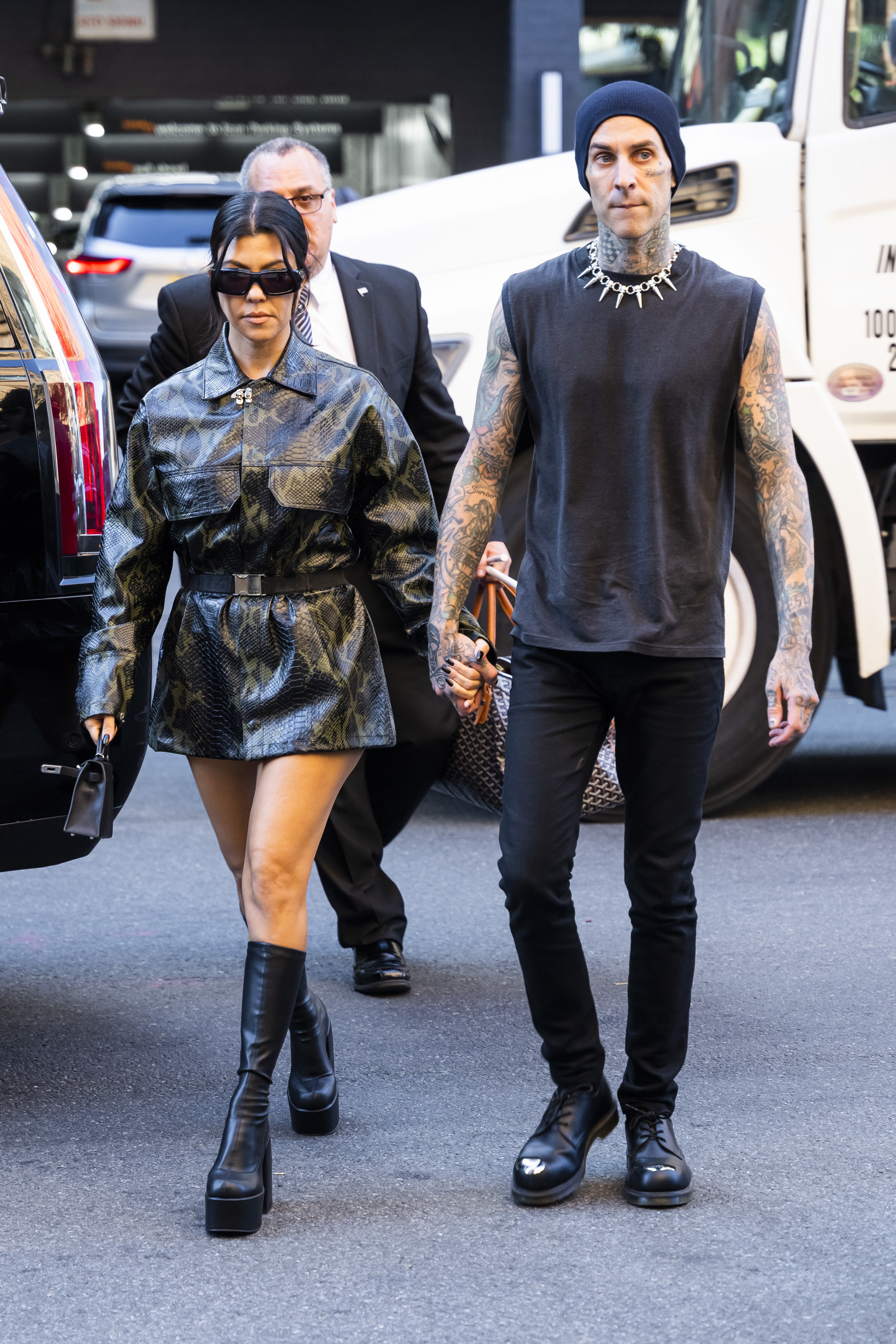 Kourtney and Travis walk together while holding hands