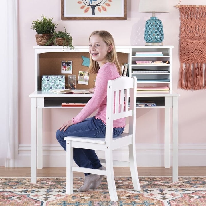 Kid sitting at white desk and chair