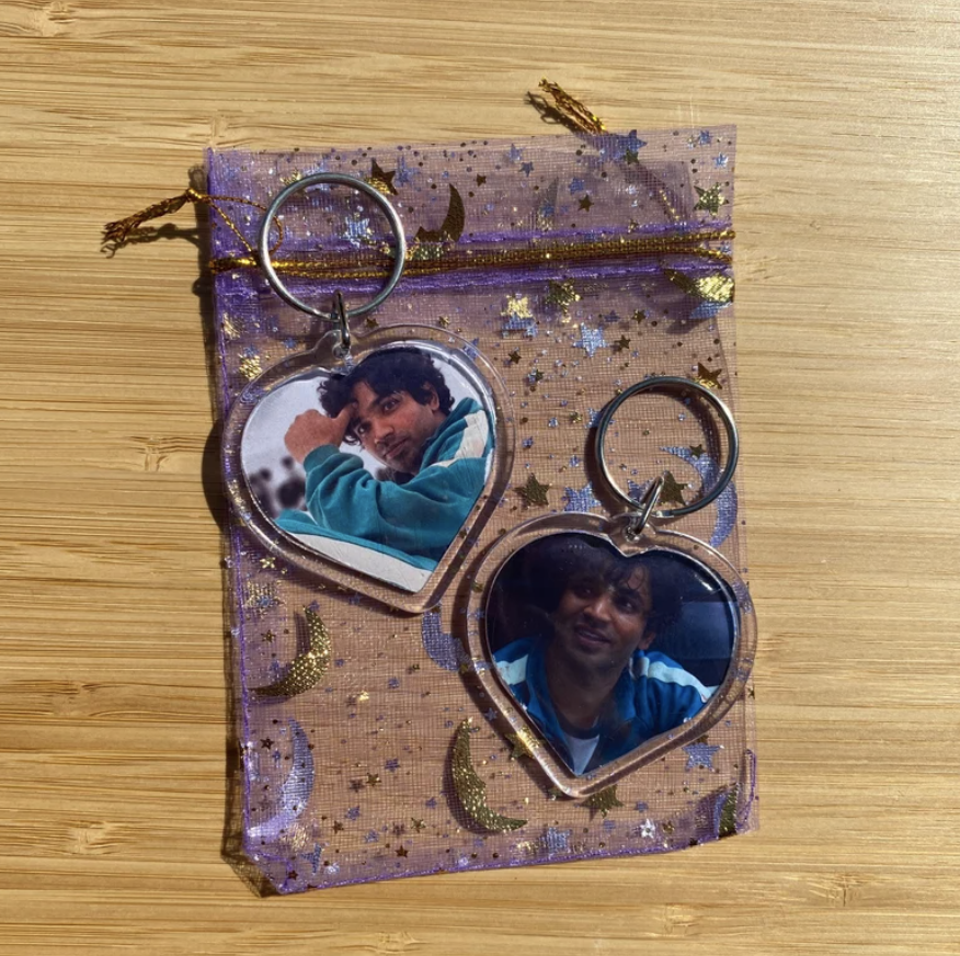 Two clear heart keychains with photos of Ali from Squid Game