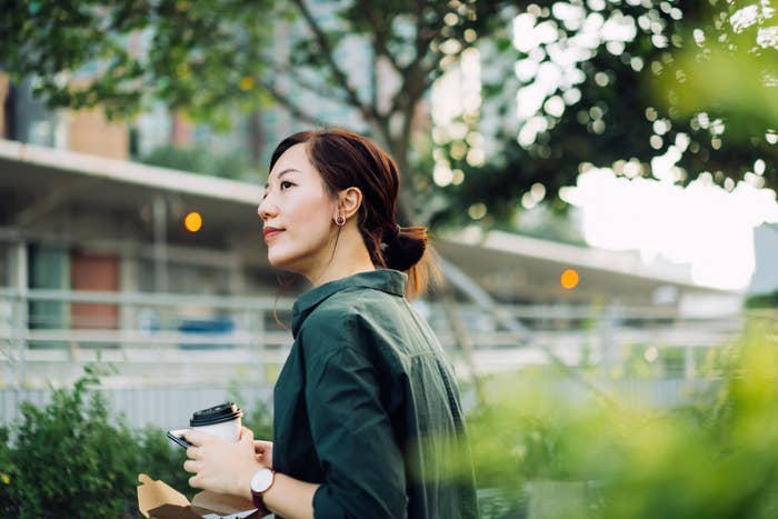 A single person eats lunch outside, looking content