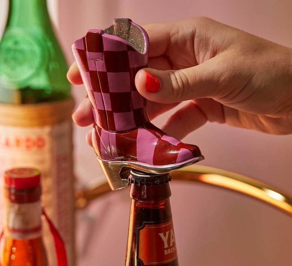 a model opening a bottle with the bootle opener