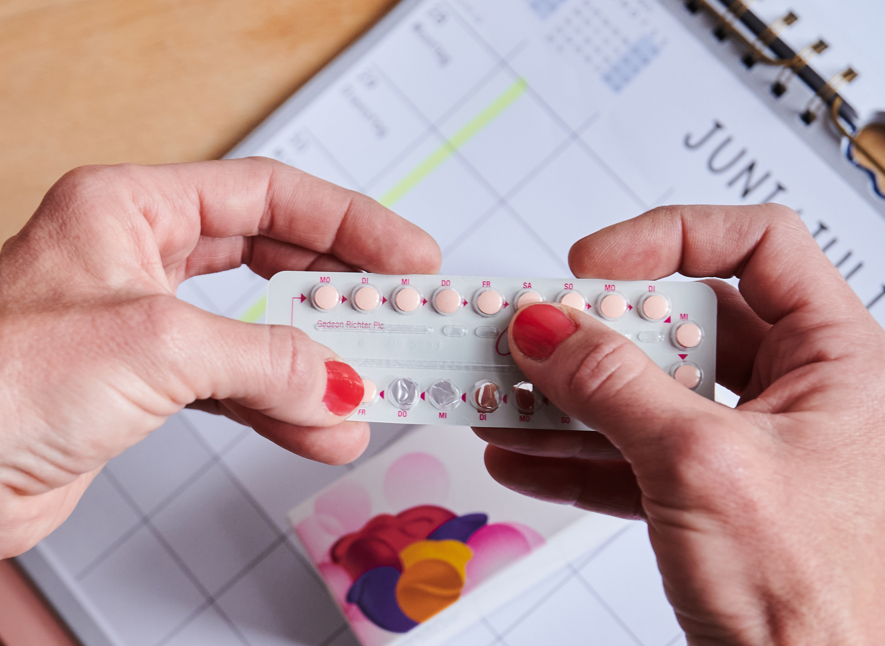 Hands hold a package of birth control pills