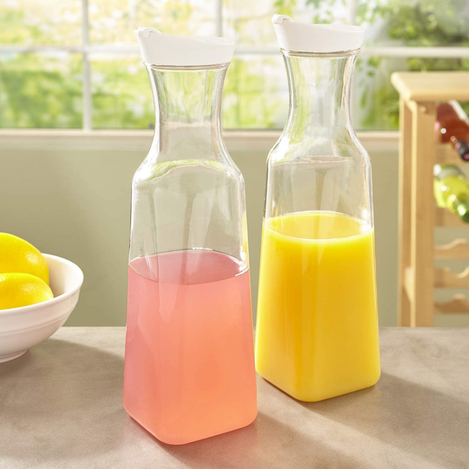 two plastic carafes filled with juice on a kitchen countertop