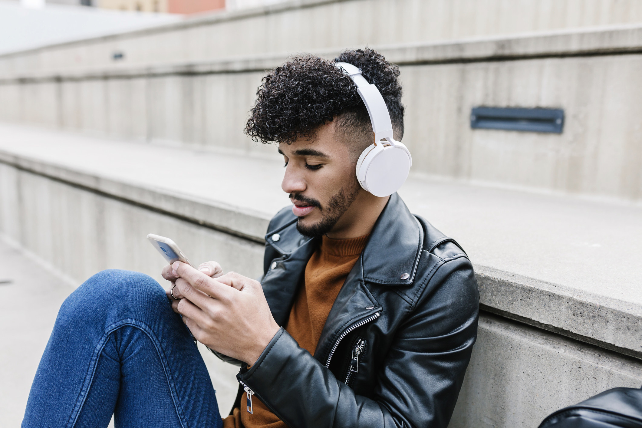 Someone sits alone, listening to music while texting