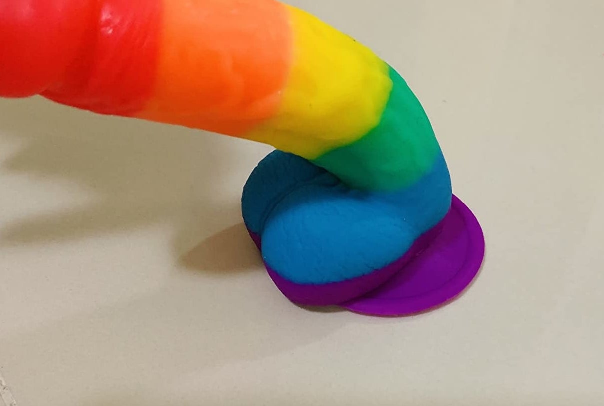 Reviewer flexing rainbow stripe realistic dildo