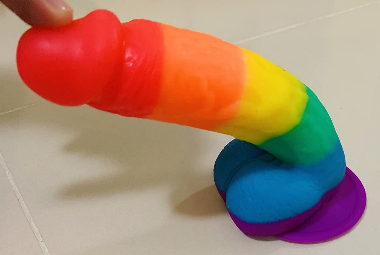 Reviewer flexing rainbow stripe realistic dildo