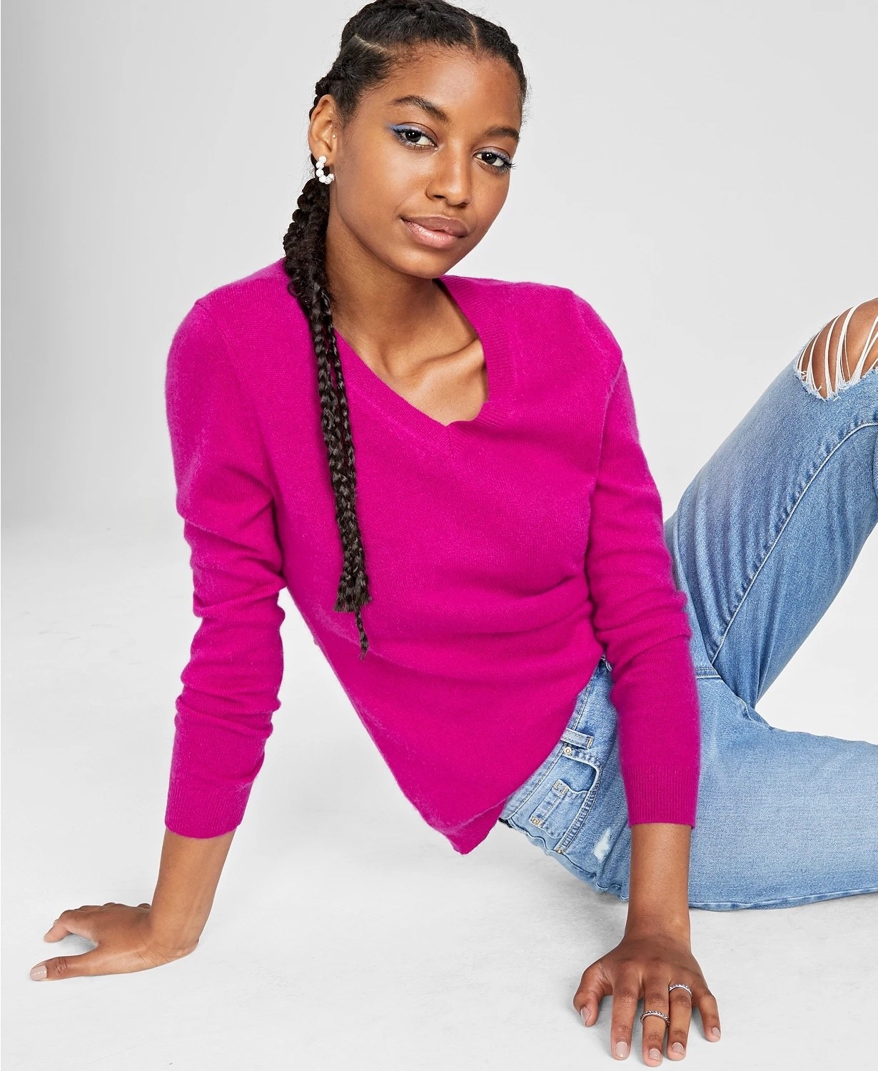 Model wearing bright pink sweater with lightwash jeans