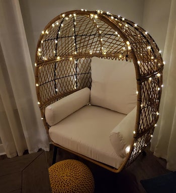 Reviewer photo of the string lights wrapped around an egg chair