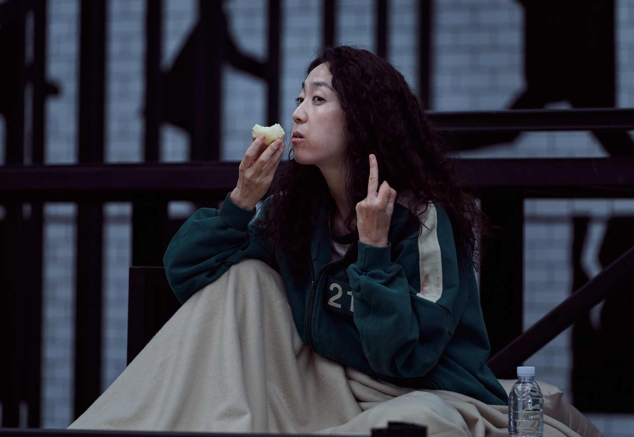 Han Mi-nyeo giving the middle finger as she sits in bed and has a snack
