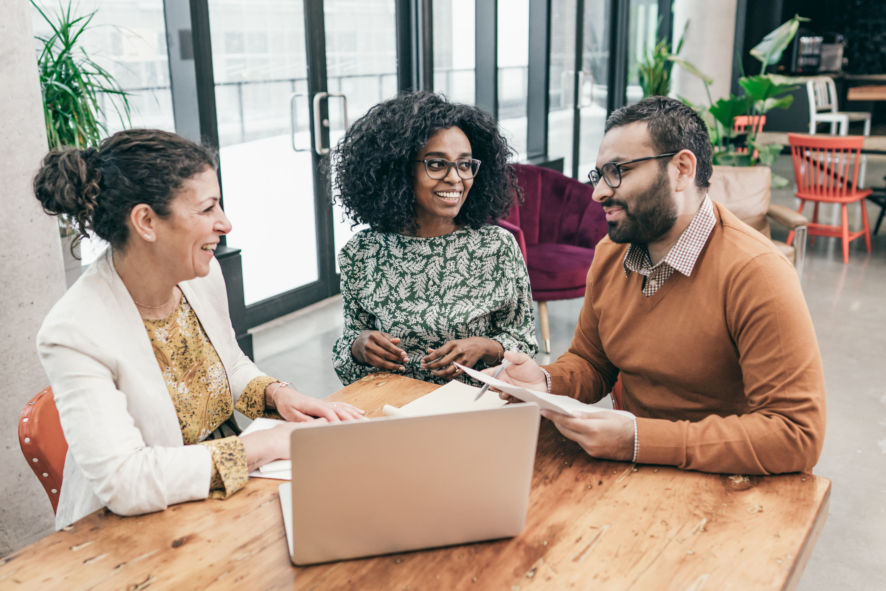 Couple meeting with lender in an office setting and going over paperwork together