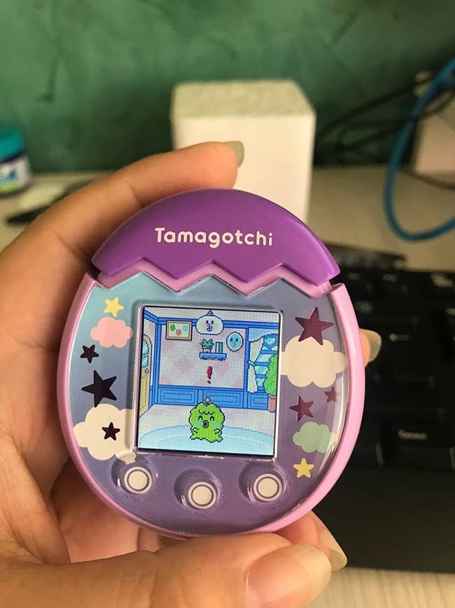 reviewer photo of them holding a tamagotchi pix in pink
