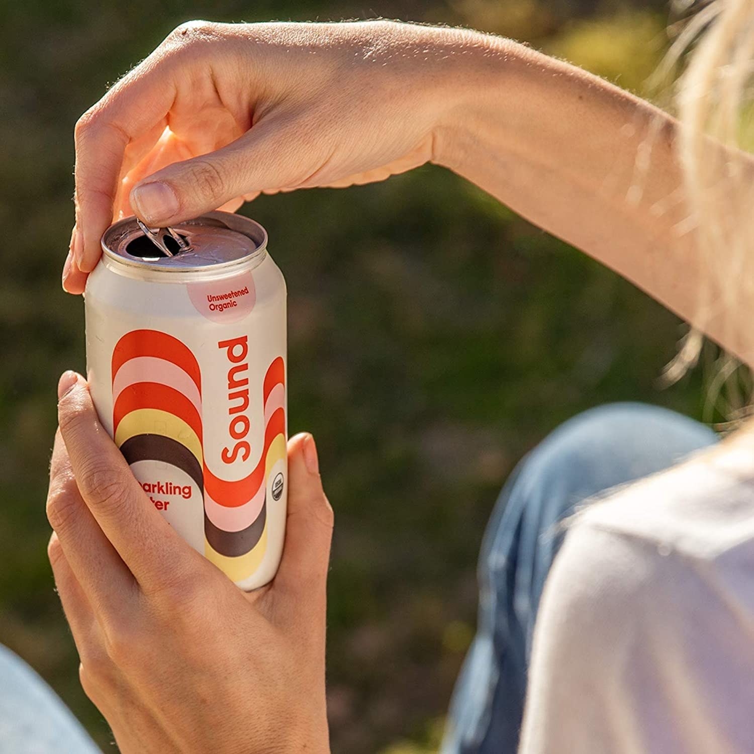 closeup of hands holding a can of the drink