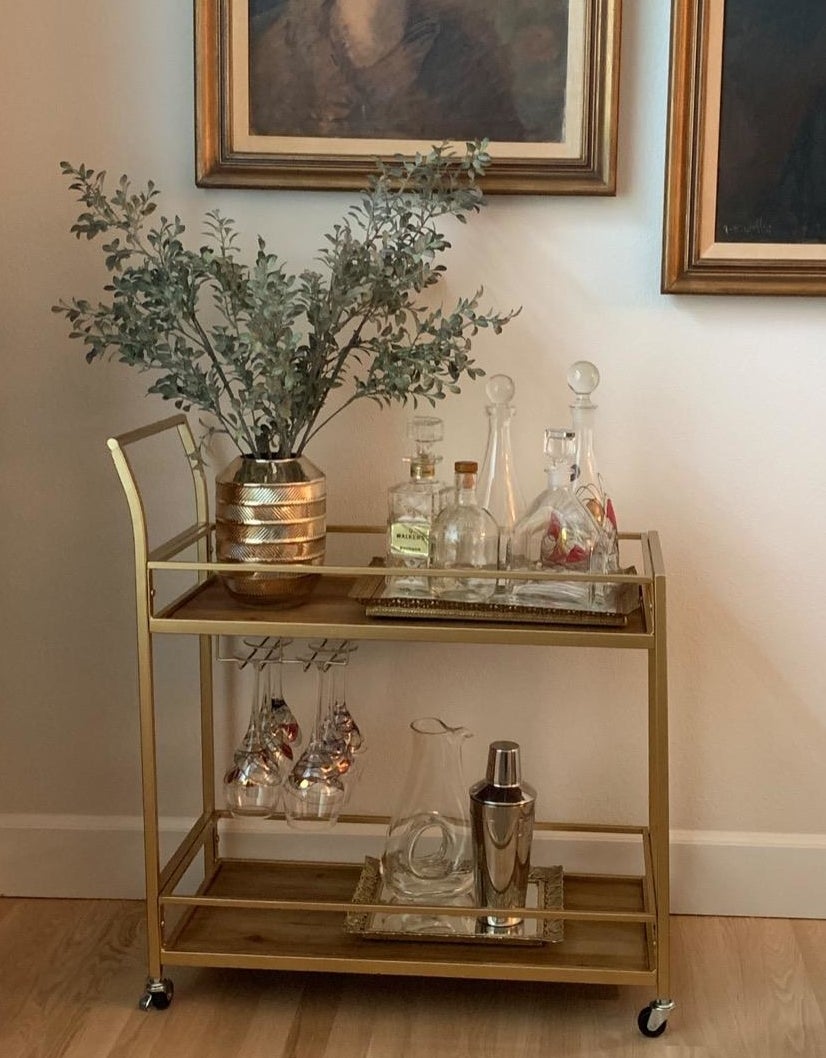 Reviewer photo of the gold bar cart filled with serving vessels
