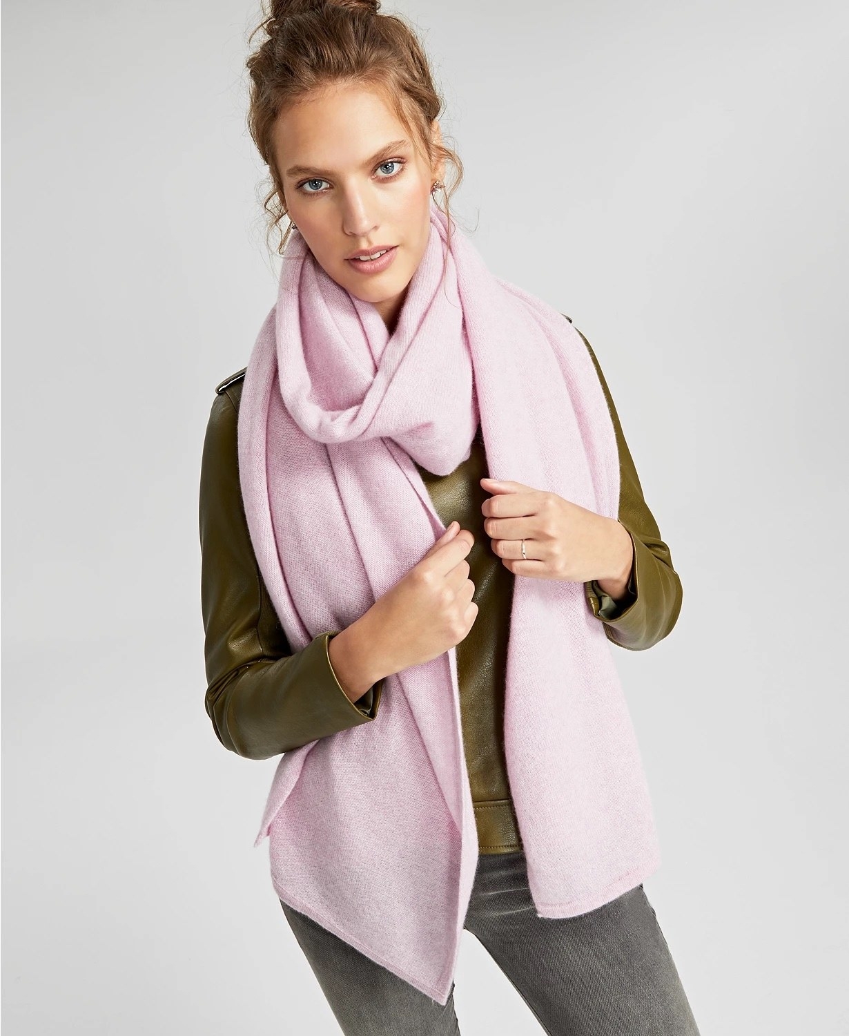 Model wearing oversized pink scarf with grey jeans and green shirt