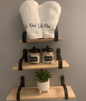 Reviewer photo of the Be Our Guest hand towels rolled up on a shelf