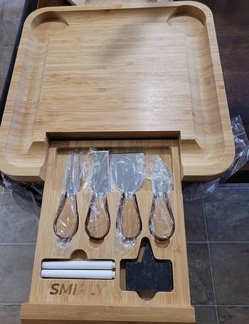 Reviewer photo of the charcuterie board and the storage drawer of utensils