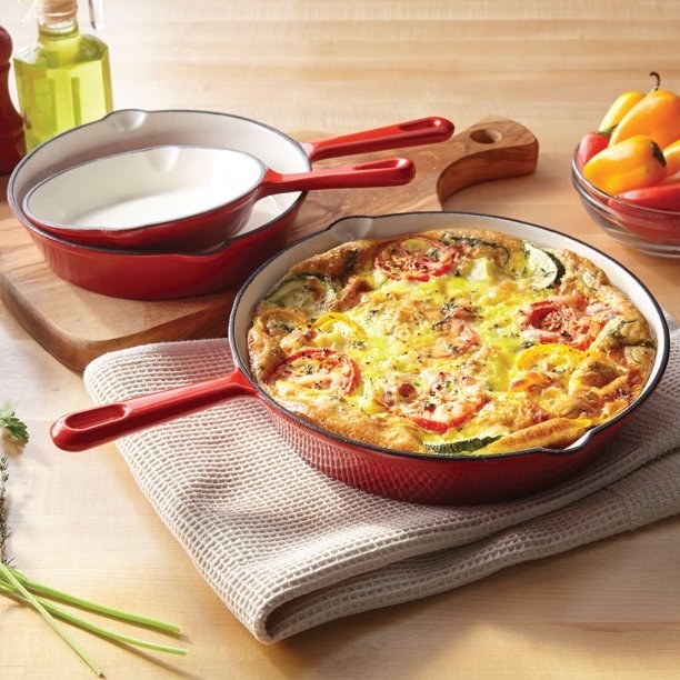 The three skillets, with the largest size serving a sizzling frittata dish