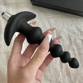Reviewer holding black beaded anal vibrator