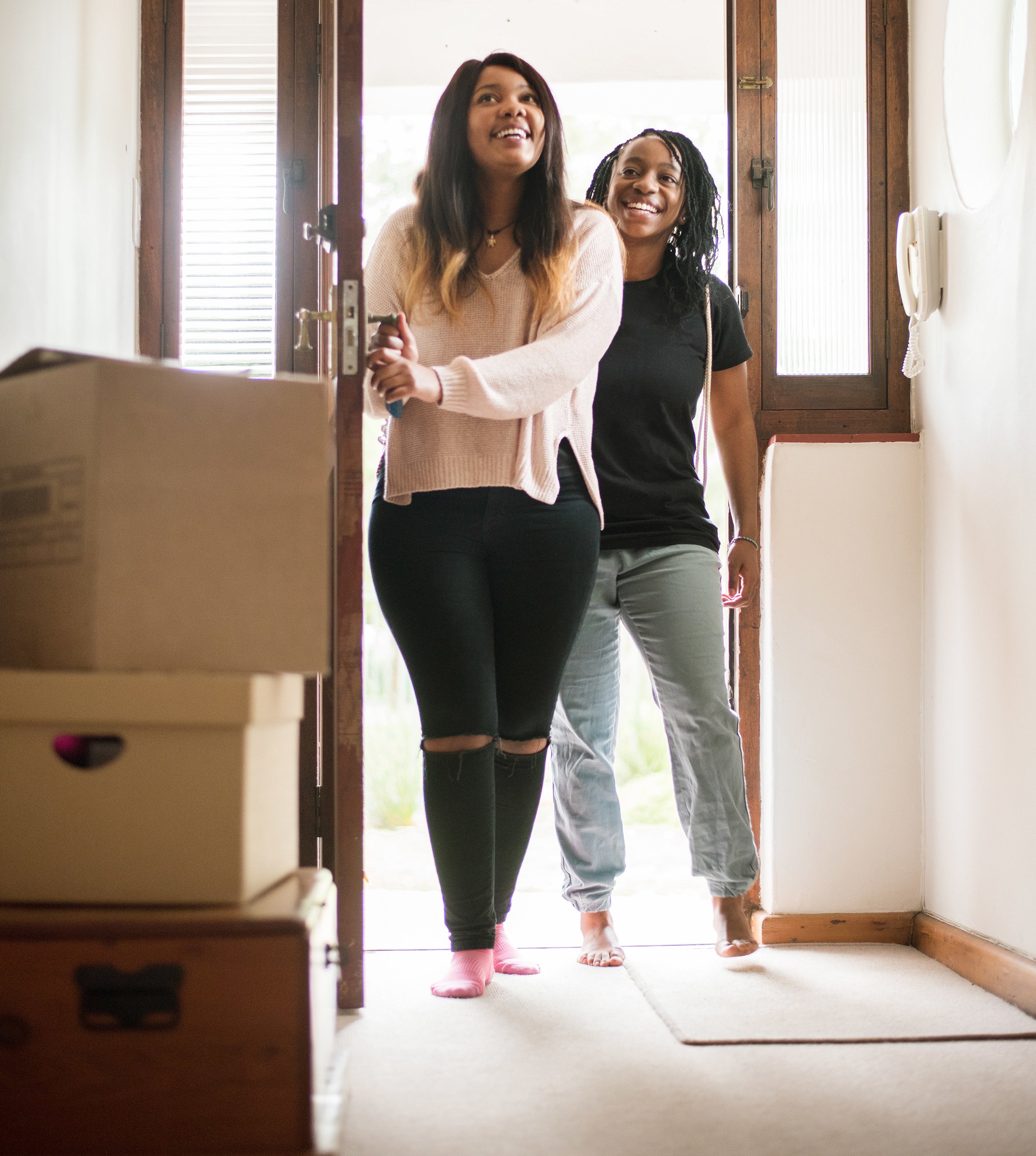 Homeowners walking into home with boxes along the floor
