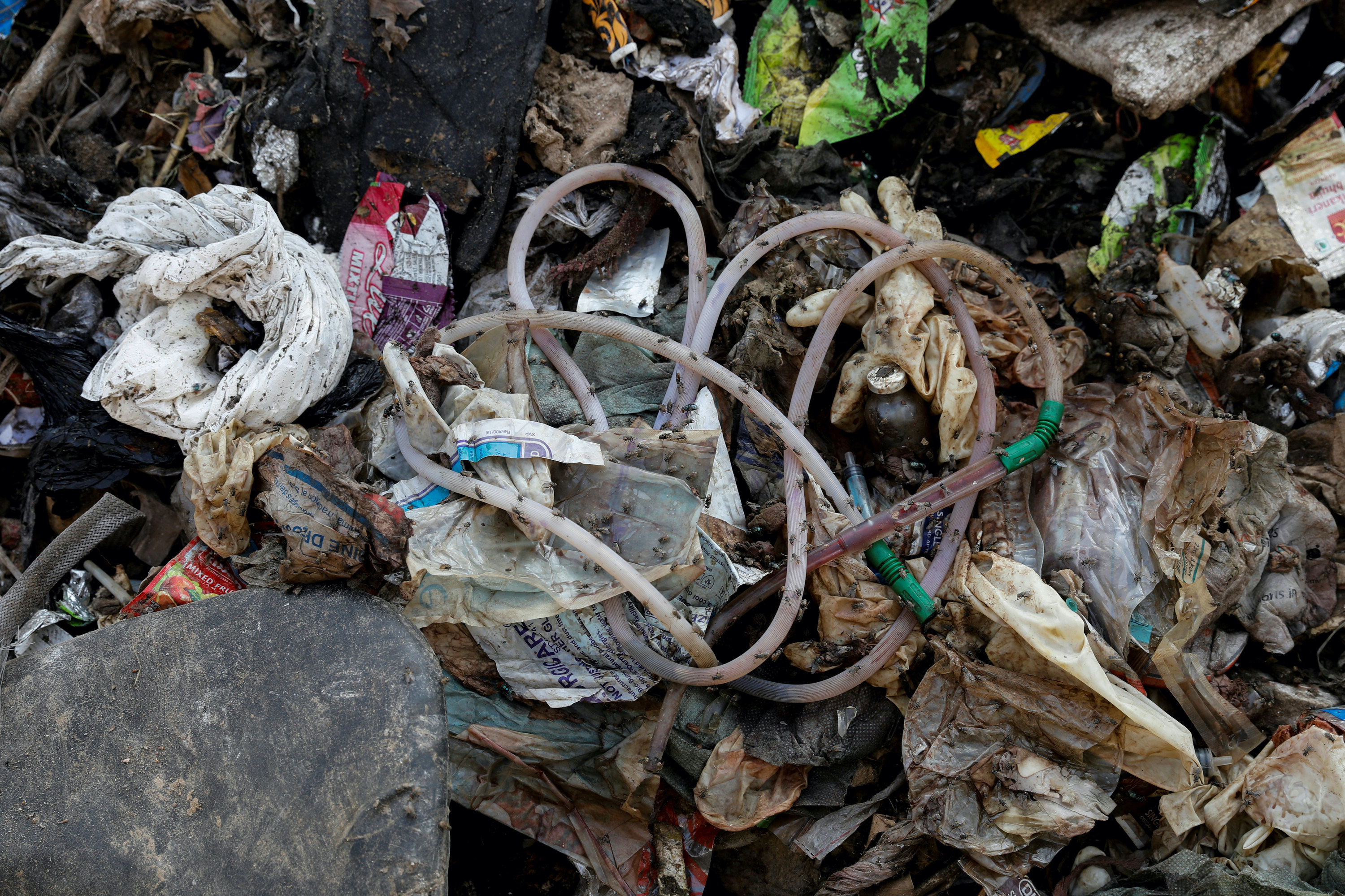 Close up view of medical supplies and waste in a landfill in India
