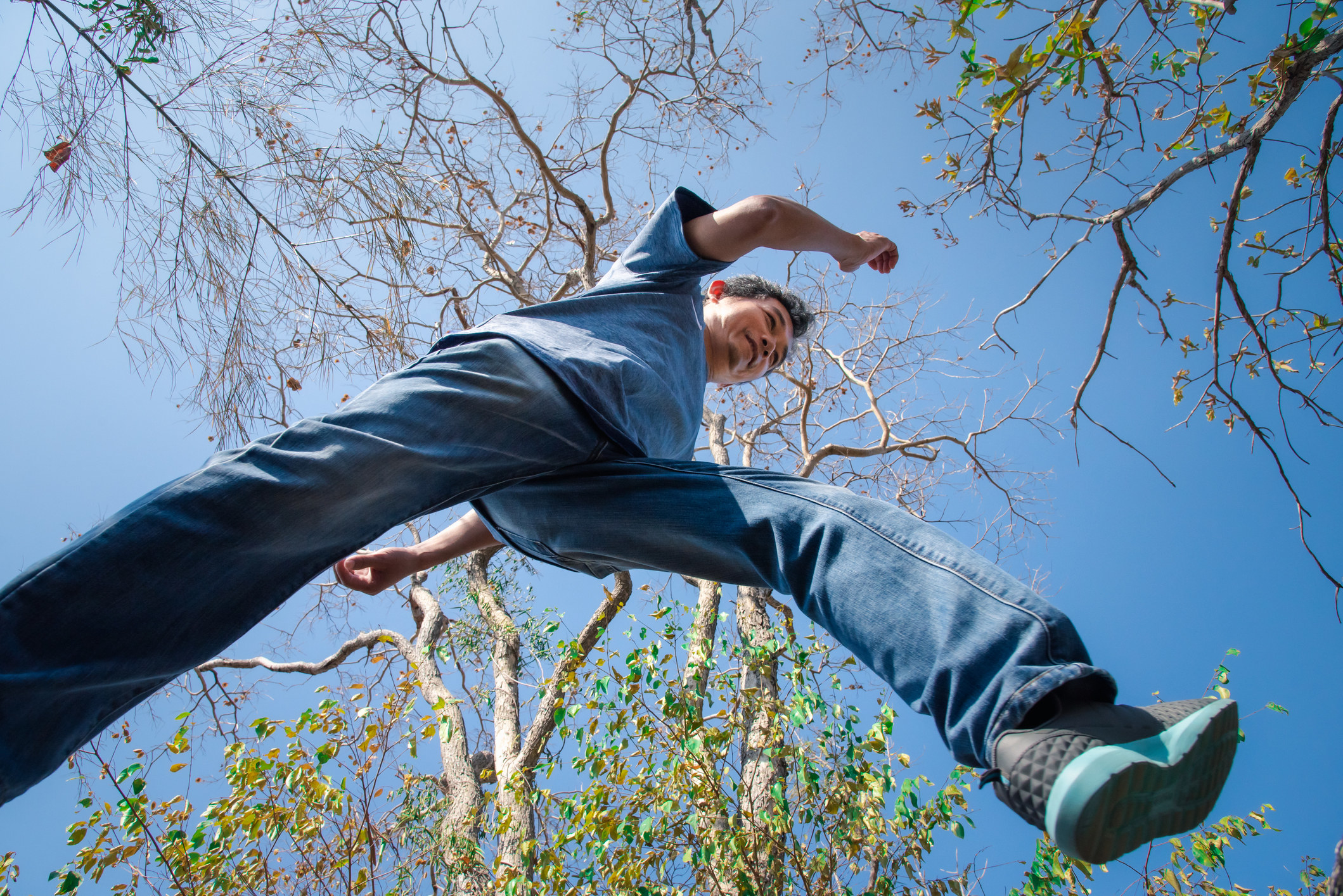 View from the ground of someone jumping over something outdoors