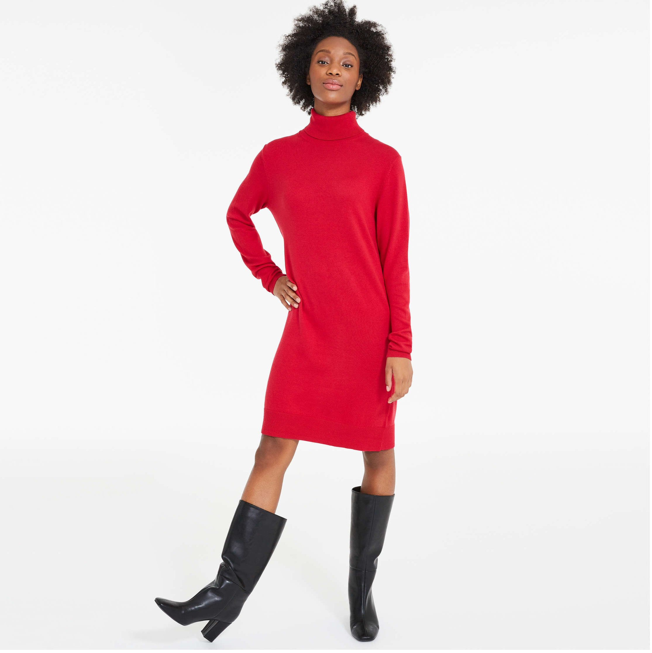 A person wearing a sweater dress with boots