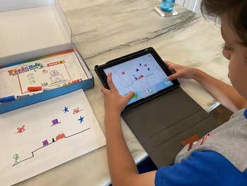 a reviewer's child playing the video game on their tablet that they created with pixicade