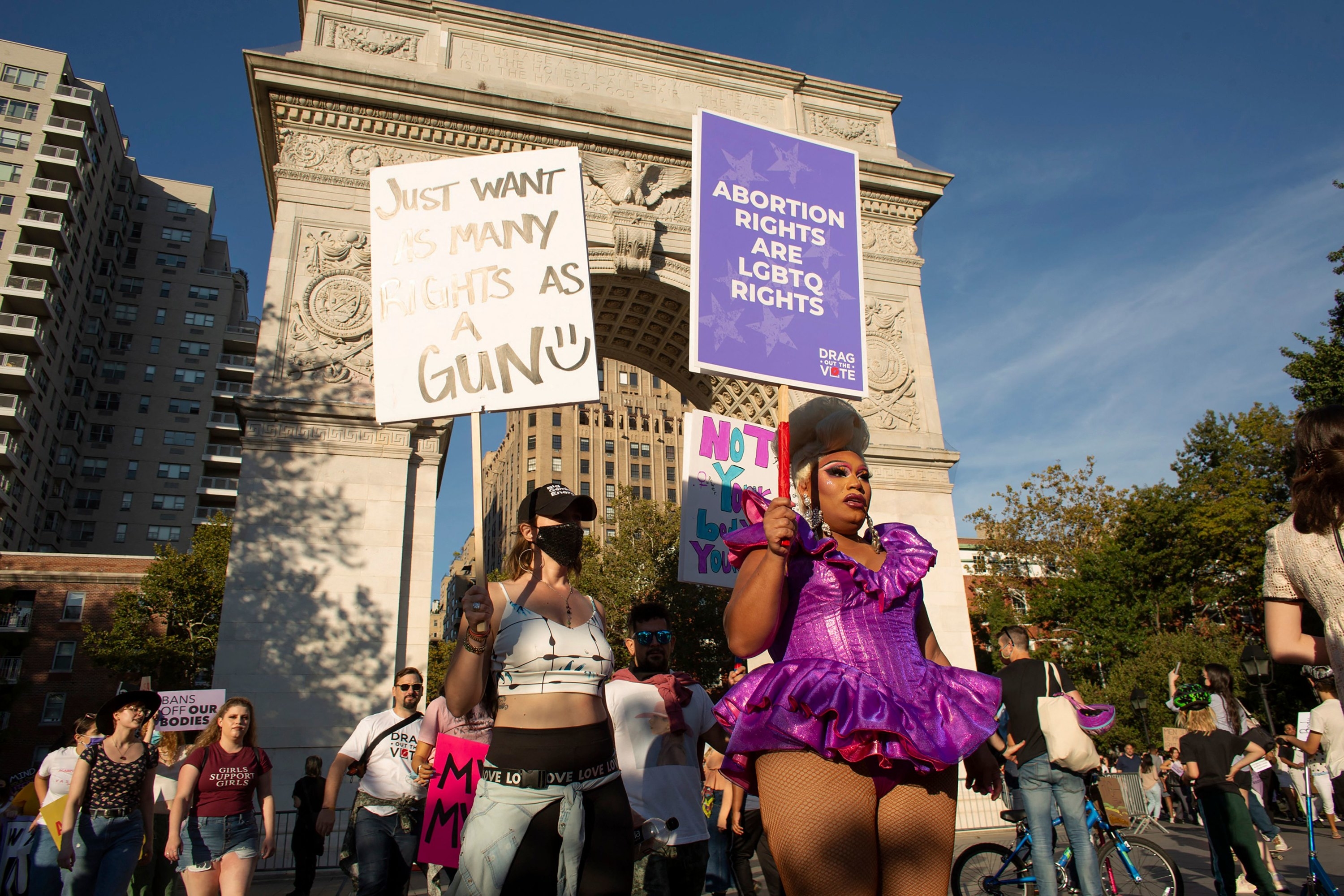 People hold up signs, including &quot;Abortion Rights Are LGBTQ Rights,&quot; at Washington Square Park