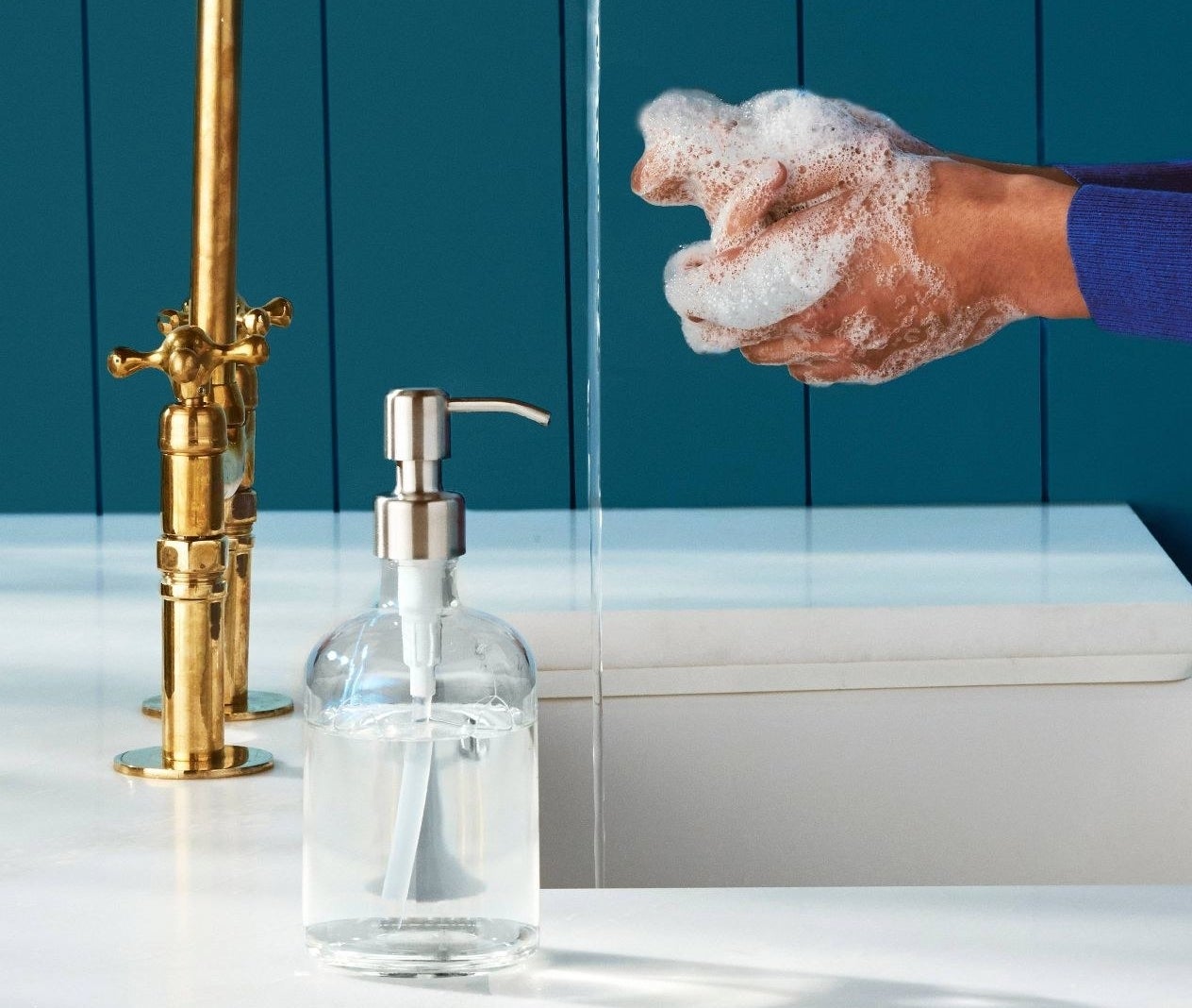 glass soap dispenser next to a sink