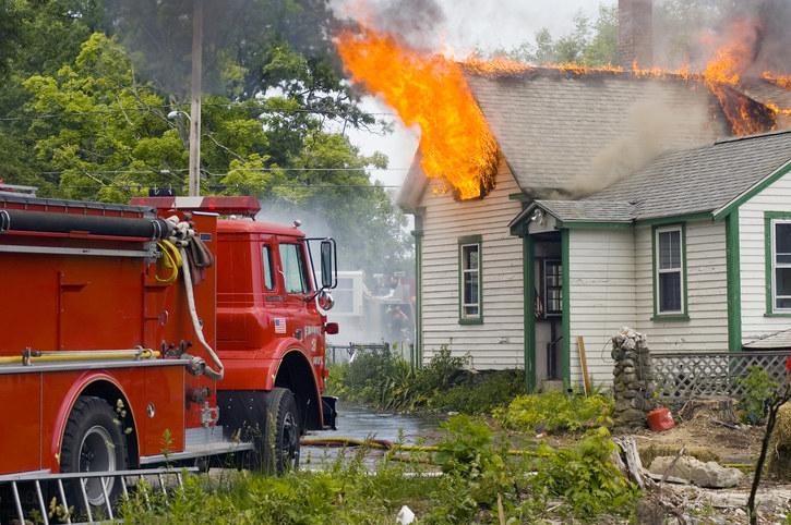 Fire truck beside a house on fire