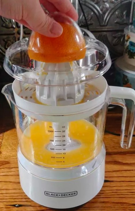 A reviewer's photo of the juicer making orange juice