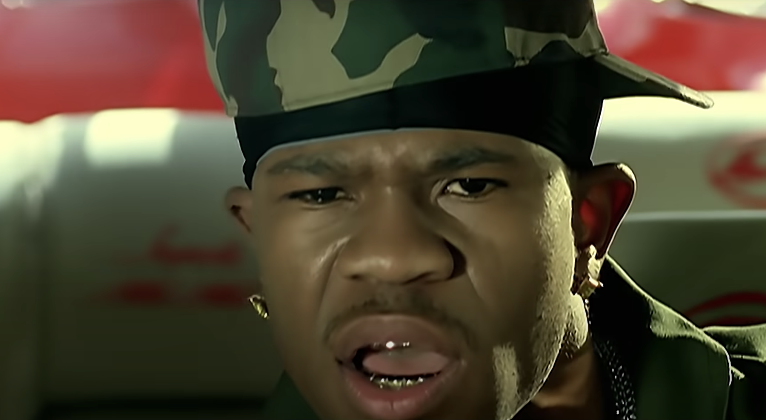 Chamillionaire rapping in a camouflage hat