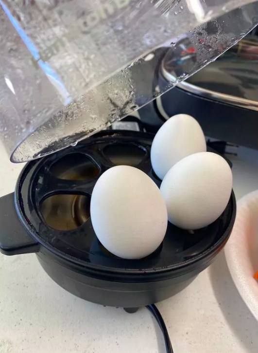 A reviewer&#x27;s photo of the egg cooker boiling three eggs