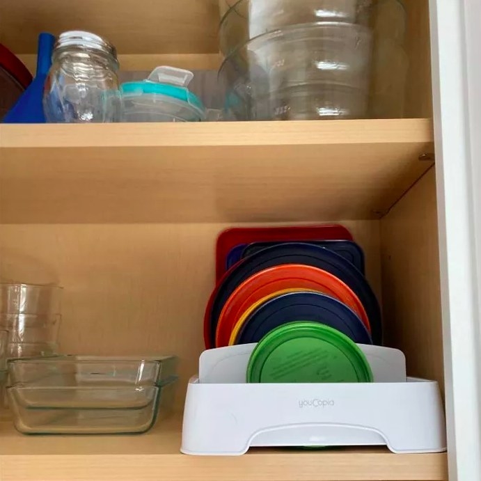 A reviewer&#x27;s photo of the organizer neatly storing her container lids
