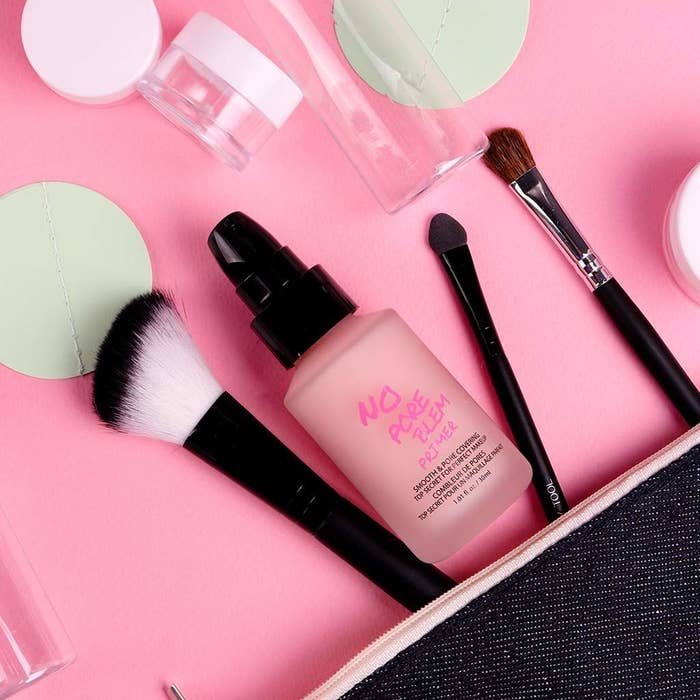 bottle of No Pore Problem styled next to makeup brushes