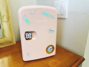 reviewer photo of pink mini fridge covered in stickers