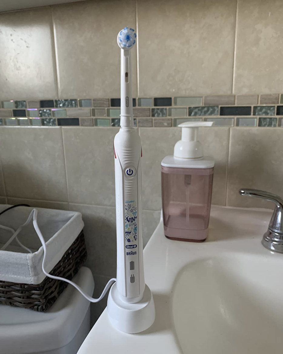 A white electric toothbrush on a stand